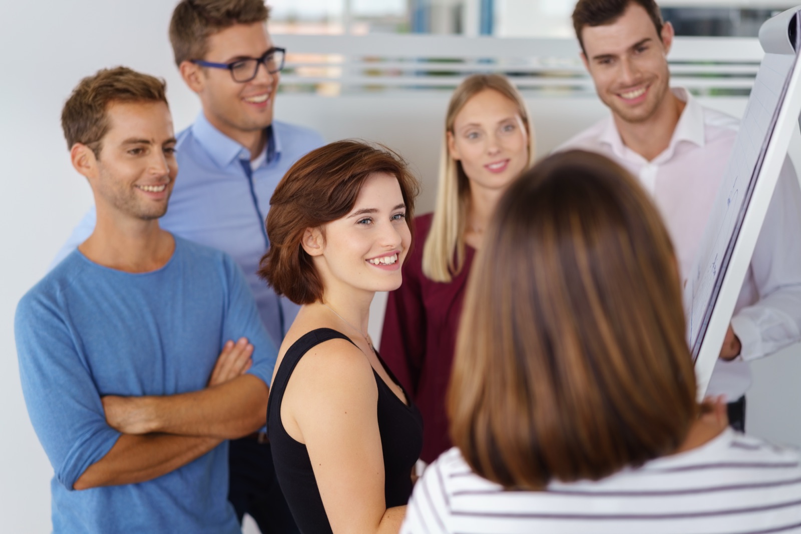 Groupe de participants en formation de coach professionnel autour d'un paperboard